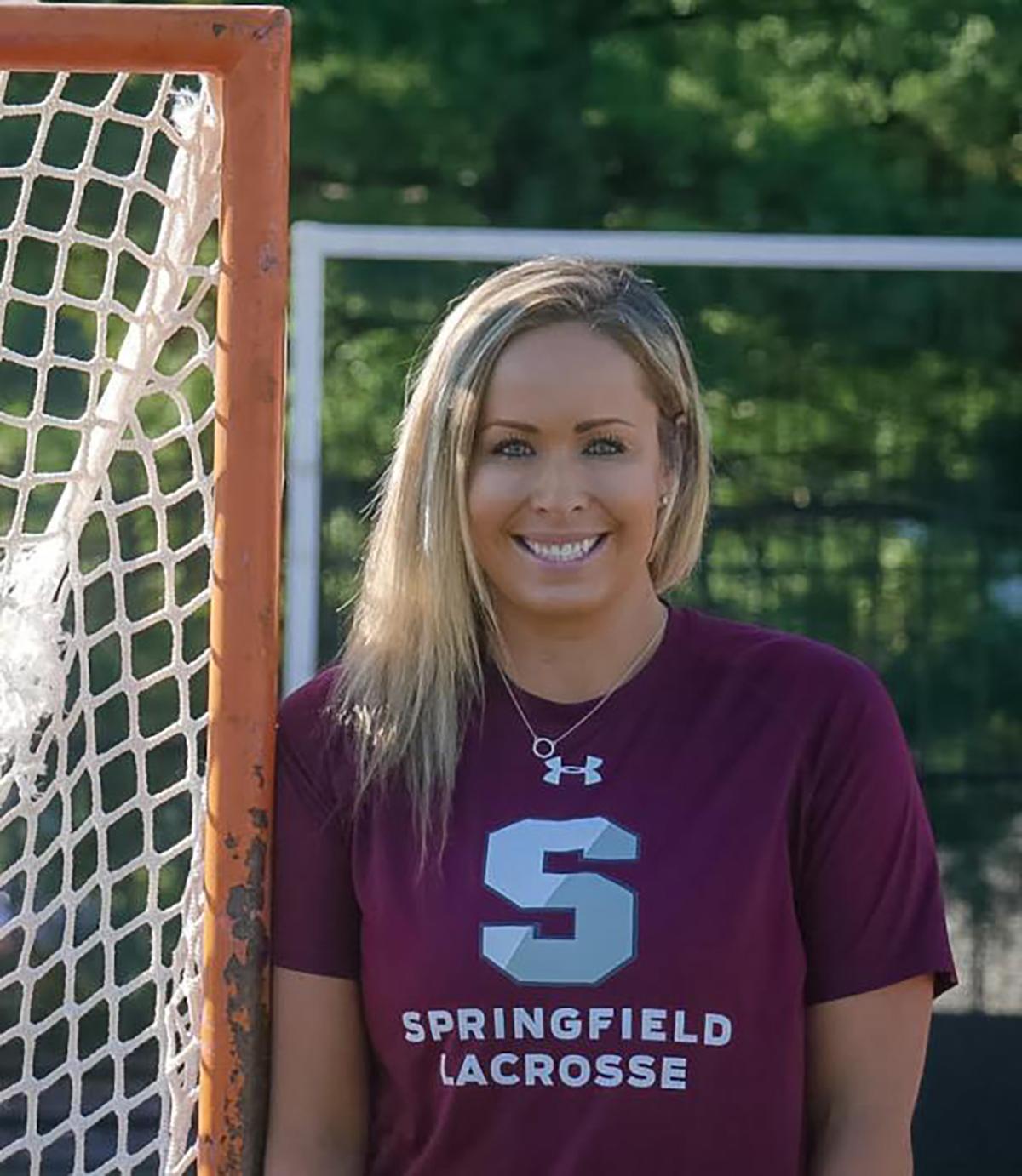 Springfield lacrosse coach Jennifer Thomas stands next to a lacrosse goal
