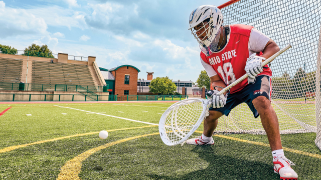 Ohio State goalie Caleb Fyock stops a shot warming up with his STX Aero helmet
